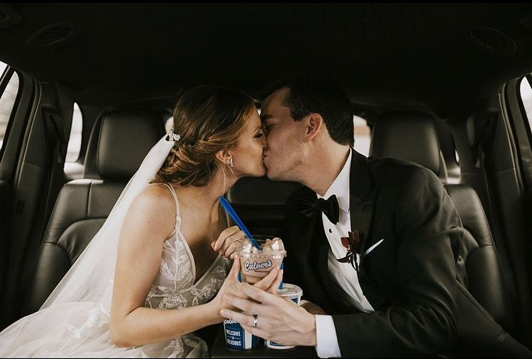Just-married couple in car kissing and holding Culver's Fresh Frozen Custard