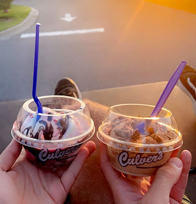 Two hands hold dishes of Fresh Frozen Custard. 