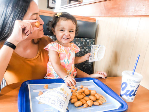 Small child and mom enjoying cheese curds at Culver's