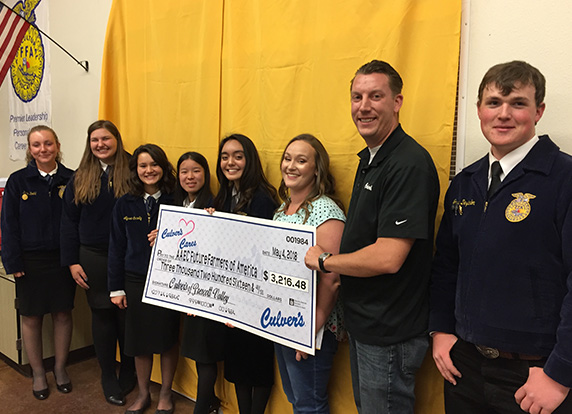 Culver’s restaurant owners present an FFA chapter with a check.