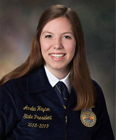 Amelia Hayden sits for a photo in her blue FFA jacket