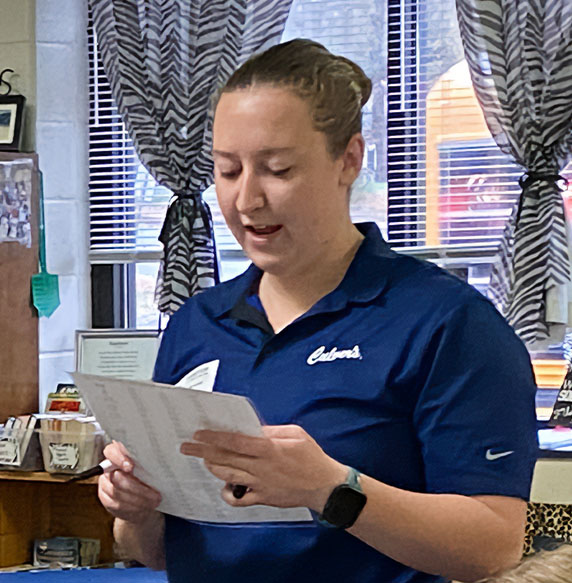 Marie reads to classroom in Culver’s shirt.