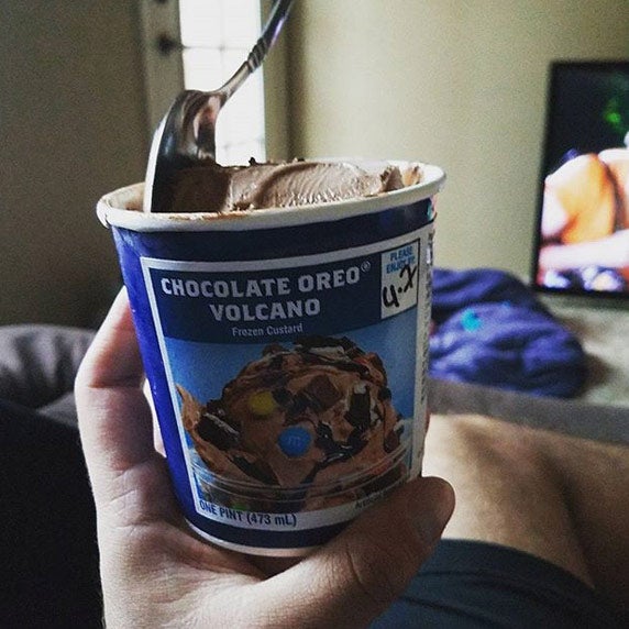 Man eating Fresh Frozen Custard on the couch.