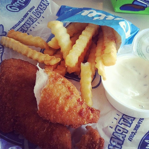 A chicken tender and crinkle cut fries from Culver’s sitting on a table next to ranch dressing