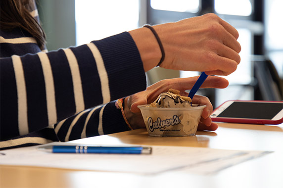 Hand begins to scoop up a bite of Culver’s Fresh Frozen Custard.