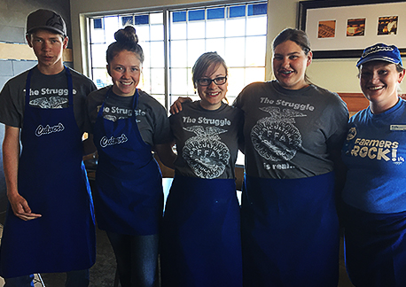 FFA members stand in a restaurant in Culver’s aprons and FFA t-shirts.