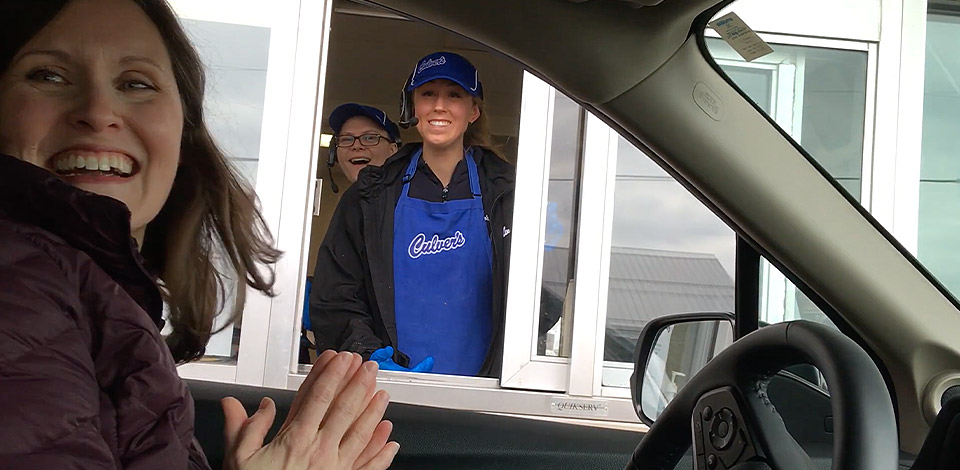Kaitlyn pictured through the Culver's Drive-Thru Window with her principal sitting in car in front of the window