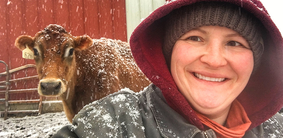 Marie takes a selfie with a cow on a snowy day.