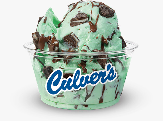 Andes chocolate pieces and strings of hardened chocolate are mixed into mint frozen custard served in a clear Culver’s dish