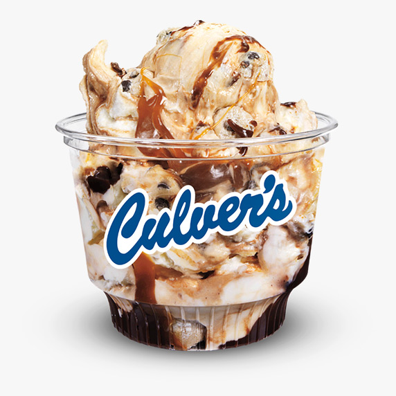 Streams of salted caramel, chocolate syrup, and cookie dough pieces are mixed into vanilla frozen custard and served in a clear Culver’s dish