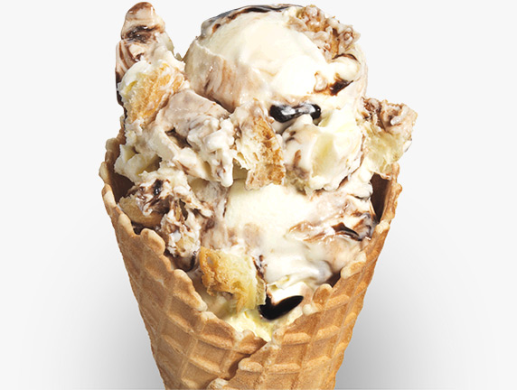 Strings of chocolate syrup and crumbles of fluffy puff pastry are mixed into vanilla frozen custard and served in a sugar cone