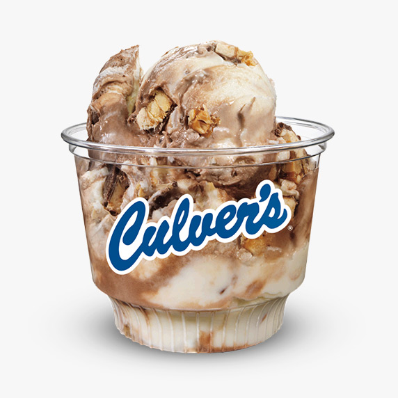 Snickers bar pieces are mixed in a mix of chocolate and vanilla frozen custard and served in a clear Culver’s dish