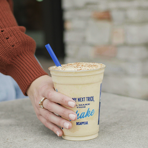 Hand reaches for Pumpkin Spice Shake.