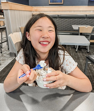 Girl eating a scoop of Vanilla Fresh Frozen Custard.