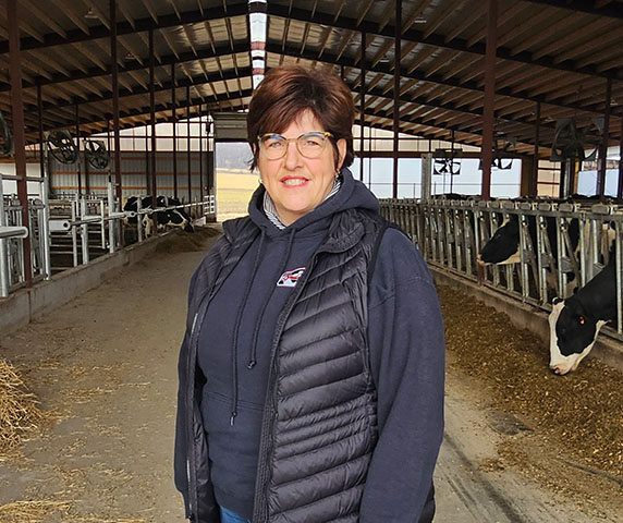Sandy Madland smiles with dairy cows