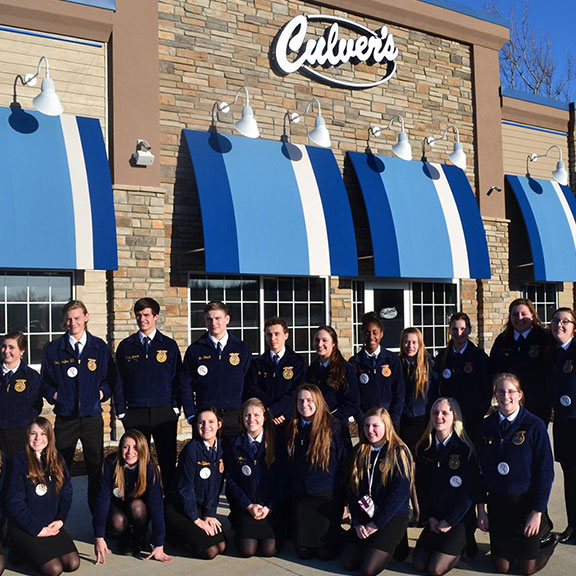 An FFA chapter poses in their blue jackets outside of a Culver’s.