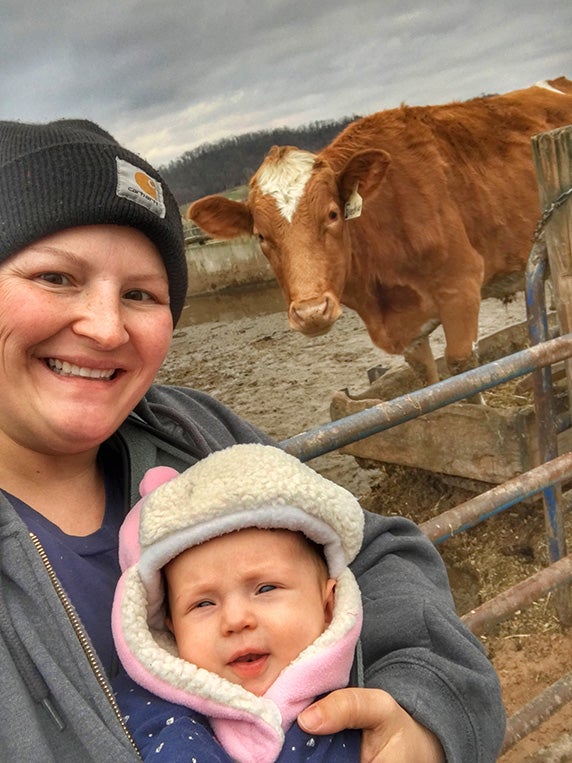 Marie and her baby daughter Millie take a selfie with a cow.