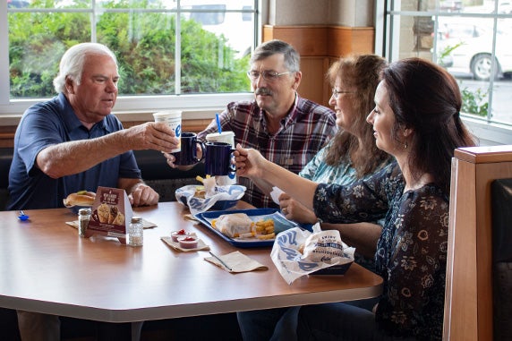 Craig Culver enjoys a meal in a corner booth with first guest Jim Olson, Jim’s wife Marion and their daughter Heather.