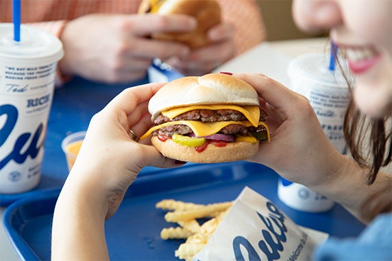 Woman holds Culver’s ButterBurger Cheese in both hands.