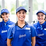 Three Team Members Pose Behind the Counter