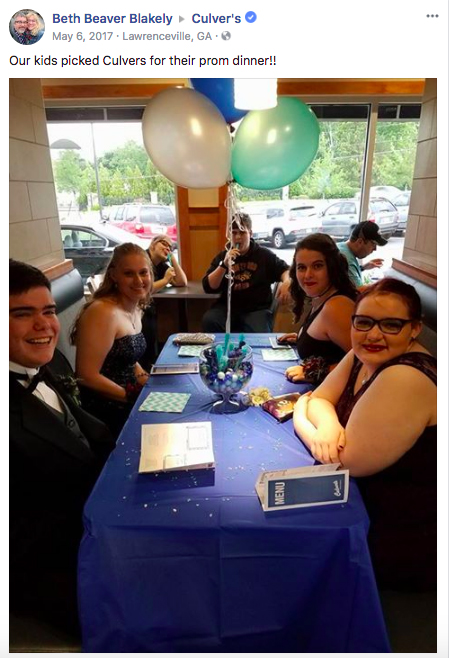 A group of high schoolers enjoy a pre-prom dinner at Culver's with balloons and a blue tablecloth.