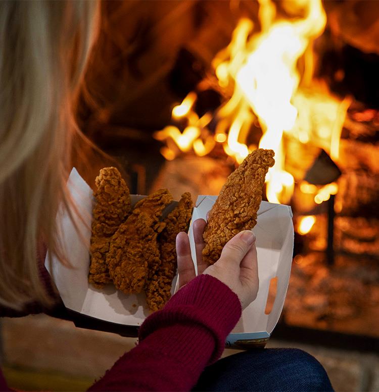 A Buffalo Chicken Tender in front of a fireplace.