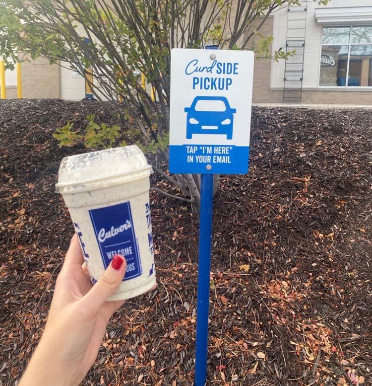 A Concrete Mixer in front of a CurdSide pickup sign. 