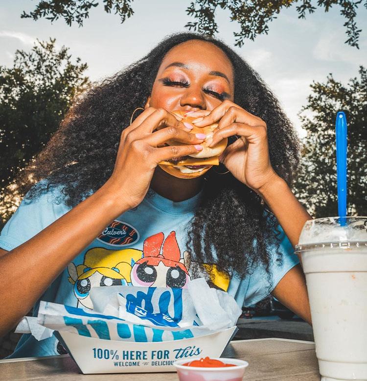 A woman eating a ButterBurger.