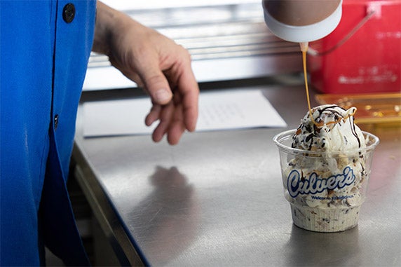 A dish of Culver’s Fresh Frozen Custard is drizzled with caramel.