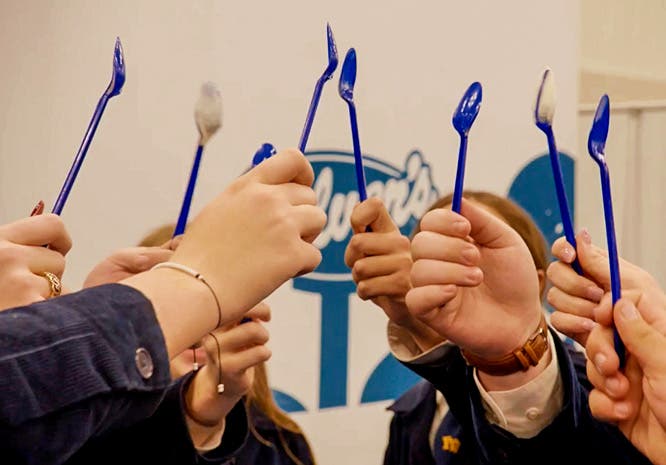 FFA members raise a blue spoon together in front of a Culver's logo.