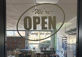 Classroom door with open sign and classroom hours