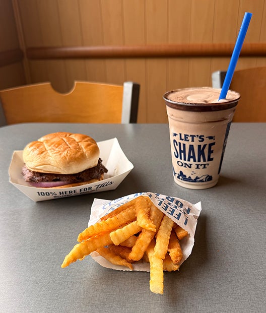 ButterBurger Value Basket sitting on table with Crinkle Cut Fries next to a Chocolate Malt