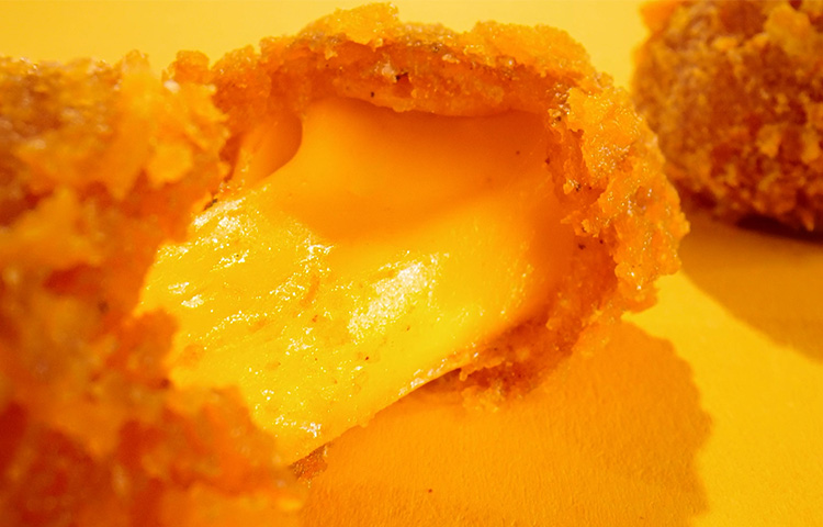 Close-up view of a Hot Honey Curd being pulled apart.