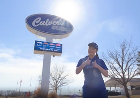 A True Blue Crew Member and Special Olympian Stands in Front of a Culver's Restaurant Sign