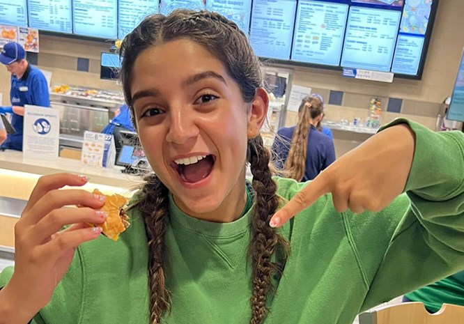 Girl smiling and pointing to a ButterBurger