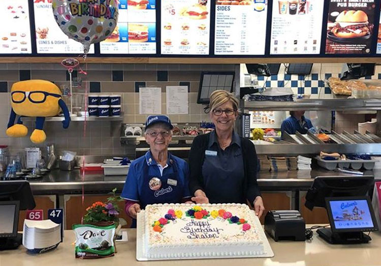 Link to story: 20 Years True Blue. Sharon and the Culver’s restaurant owner pose with a birthday cake.
