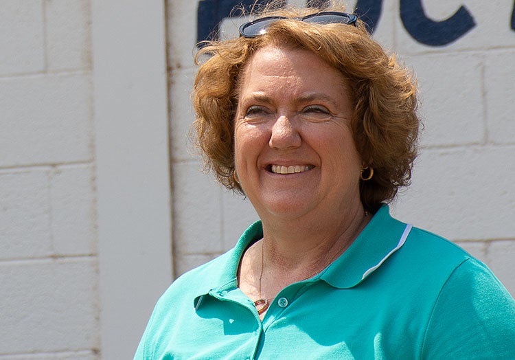 NCBA President Jennifer Houston poses in front of a livestock barn.