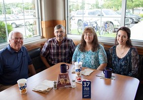 Link to story: Our very first guest. Craig Culver enjoys a meal in a corner booth with first guest Jim Olson, Jim’s wife Marion and their daughter Heather.