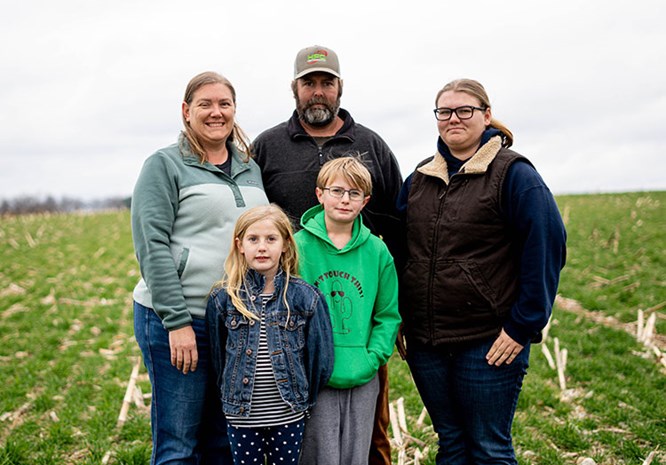 Family standing in a farm field