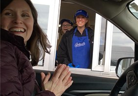 Link to story: The Drive-Thru Valedictorian. Kaitlyn pictured through the Culver’s Drive-Thru Window with her principal sitting in car in front of the window