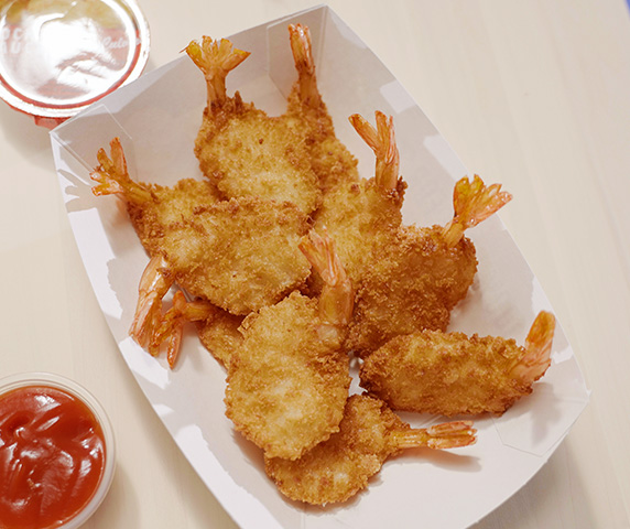 Butterfly Jumbo Shrimp on a table with ketchup and Cocktail Sauce.