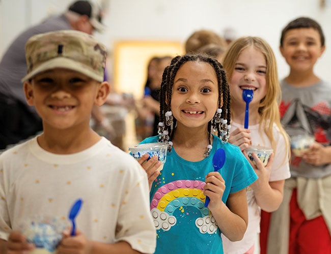 A group of children smile as they hold their dishes of Fresh Frozen Custard.