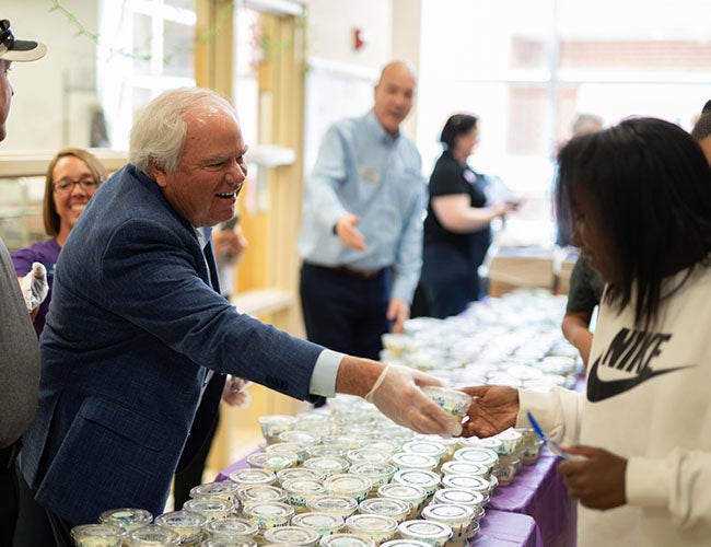 Craig Culver hands a dish of Fresh Frozen Custard to a young girl.